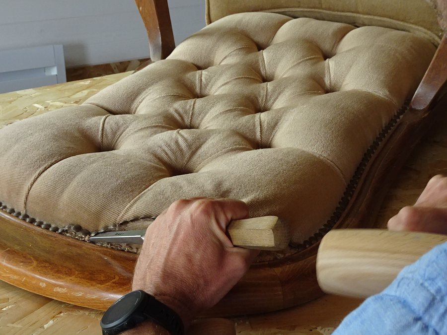 Philippe Noret retirant la garniture capitonnée d'un fauteuil